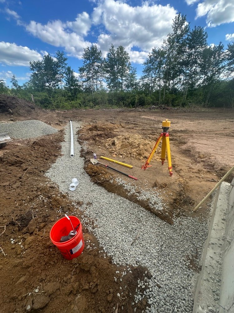 Gravel bed utility trench with survey equipment
